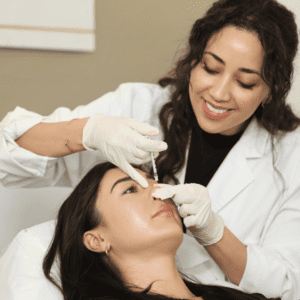 Smiling person performing nose filler treatment